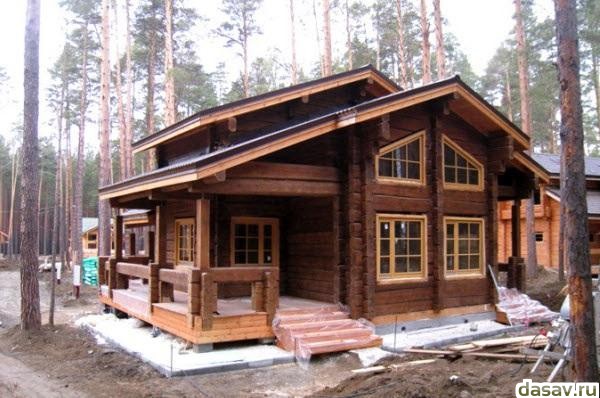 Деревянные дома из оцилиндрованного бревна и лафета зимой